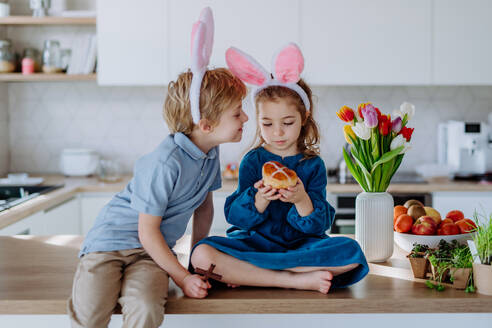 Kleine Geschwister genießen die Osterzeit gemeinsam in ihrem Haus. - HPIF12794