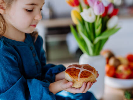 Kleines Mädchen, das ein Ostergebäck hält, um Ostern und den Frühling zu feiern. - HPIF12795
