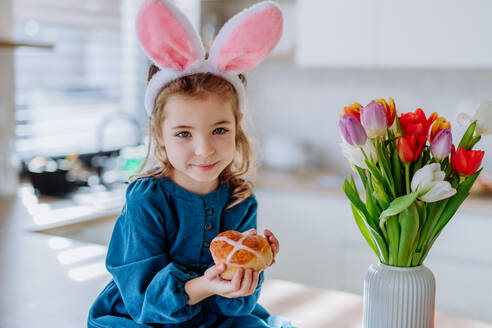 Kleines Mädchen, das ein Ostergebäck hält, um Ostern und den Frühling zu feiern. - HPIF12796