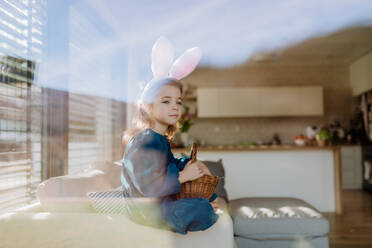 Porträt eines kleinen Mädchens, das einen Korb mit Ostereiern hält. - HPIF12804