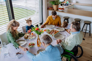 Close-up of family holding hands, praying before Easter dinner. - HPIF12828