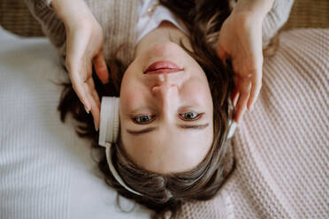 Top view of young woman listening music trough a headphones. - HPIF12851