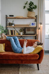 Young woman scrolling her smartphone in an apartment. - HPIF12875