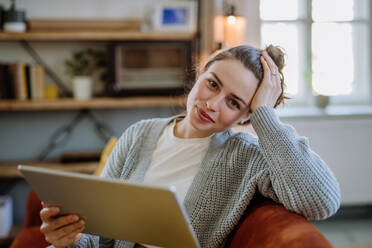 Young woman with digital tablet resting in the apartment. - HPIF12877