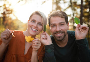 Close-up of young couple in love on a walk in autumn forest, having fun. - HPIF12970