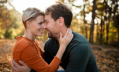 Close-up of young couple in love on a walk in autumn forest, hugging. - HPIF12971