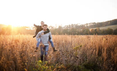 Glückliches, verliebtes junges Paar bei einem Spaziergang im herbstlichen Wald, mit Handschleifendrachen. - HPIF12976