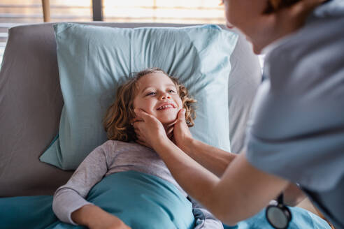 Freundliche Ärztin mit Stethoskop bei der Untersuchung eines kleinen Mädchens im Bett im Krankenhaus. - HPIF13054