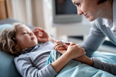 Fürsorgliche Mutter, die ihre kleine Tochter im Krankenhaus im Bett besucht. - HPIF13064