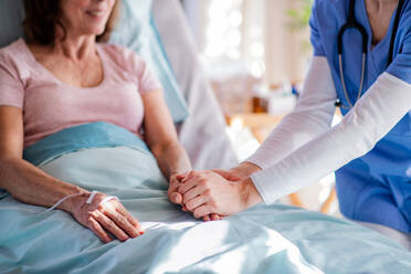 Unbekannter Arzt im Gespräch mit älterem Patienten im Bett im Krankenhaus, Mitte. - HPIF13071