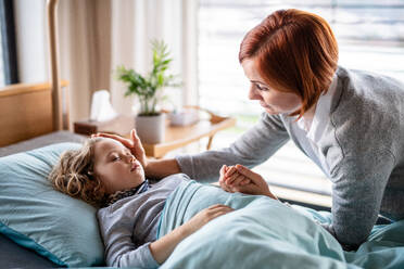 Eine fürsorgliche Mutter besucht ihre schlafende kleine Tochter im Bett im Krankenhaus. - HPIF13091