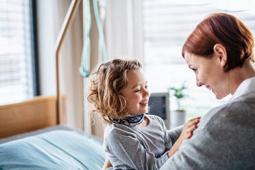 Fürsorgliche Mutter, die ihre kleine Tochter im Krankenhaus besucht, Kopierraum. - HPIF13095