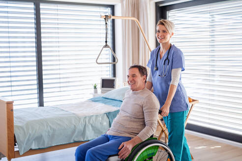 Eine Pflegekraft und ein älterer Patient im Rollstuhl im Krankenhaus oder zu Hause. - HPIF13102