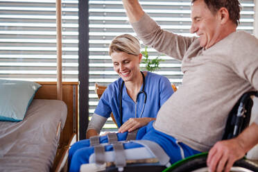 Eine Pflegekraft und ein älterer Patient im Rollstuhl, Konzept der Physiotherapie. - HPIF13116