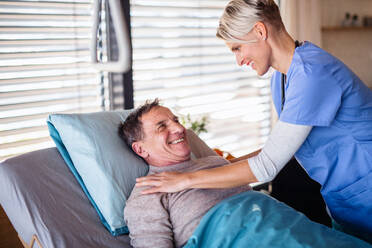 A friendly healthcare worker and senior patient in hospital, talking. - HPIF13158