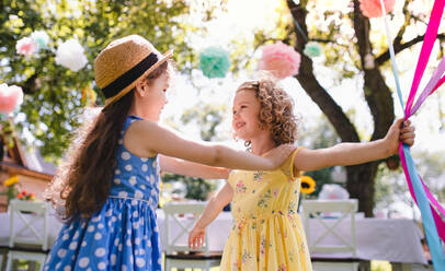 Kleine Kinder, die im Sommer draußen im Garten spielen, ein Konzept für ein Fest. - HPIF13171