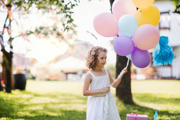 Kleines Mädchen im Freien im Garten im Sommer, spielen mit Luftballons. Eine Feier Konzept. - HPIF13207