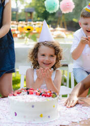 Frontansicht des kleinen Mädchens mit Kuchen feiern Geburtstag im Freien im Garten im Sommer, Party-Konzept. - HPIF13213