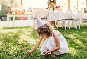 Small girl playing outdoors on garden party in summer, a celebration concept. - HPIF13217