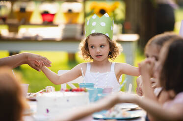 Frontansicht des kleinen Mädchens mit Kuchen feiern Geburtstag im Freien im Garten im Sommer, Party-Konzept. - HPIF13229