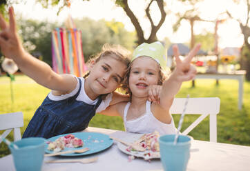 Glückliche kleine Mädchen sitzen am Tisch auf Sommergarten Party, Geburtstagsfeier Konzept. - HPIF13232