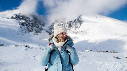 Front view portrait of happy smiling woman standing in snowy winter nature. - HPIF13314