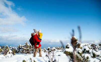 Father holding small son in snow in winter nature, holiday in Slovakia concept. Copy space. - HPIF13316