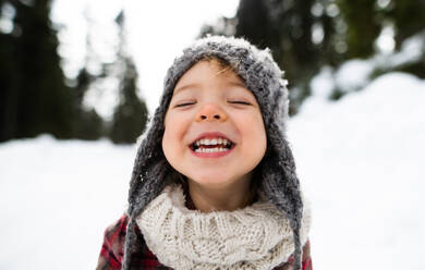 Frontansicht Nahaufnahme Porträt von fröhlichen kleinen Kleinkind Mädchen stehen im Winter Natur, Blick auf die Kamera. - HPIF13346