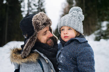 Close-up portrait of father with small son in snowy winter nature, talking. - HPIF13353