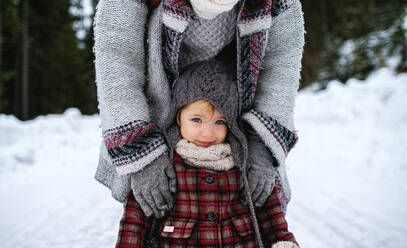 Midsection of unrecognizable mother with small daughter standing in winter nature. - HPIF13356