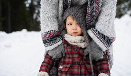 Mittelteil einer nicht erkennbaren Mutter mit kleiner Tochter in winterlicher Natur. - HPIF13357