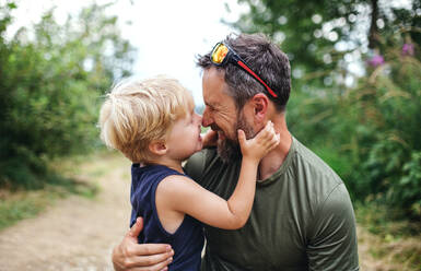 Älterer Vater mit kleinem Sohn beim Wandern in der sommerlichen Natur, der Spaß hat. - HPIF13397