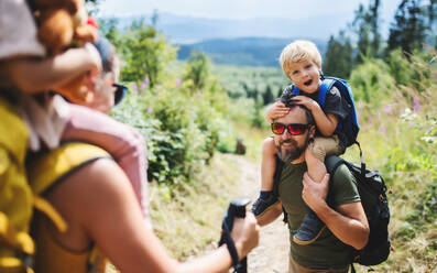Glückliche Familie mit kleinen Kindern beim Wandern in der sommerlichen Natur. - HPIF13417