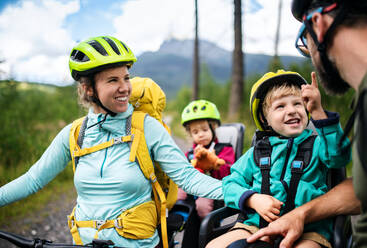 Glückliche Familie mit kleinen Kindern beim Radfahren in der sommerlichen Natur. - HPIF13425