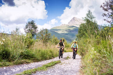 Happy family with small children cycling outdoors in summer nature, High Tatras in Slovakia. - HPIF13427