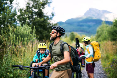 Happy family with small children with bicycles outdoors in summer nature, High Tatras in Slovakia. - HPIF13433