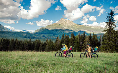 Glückliche Familie mit kleinen Kindern beim Radfahren in der sommerlichen Natur, Tatra-Gebirge, Slowakei. - HPIF13435