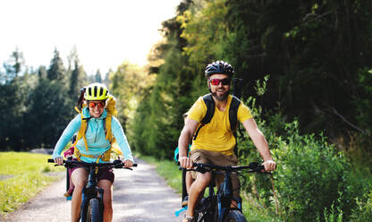 Glückliche Familie mit kleinen Kindern beim Radfahren in der sommerlichen Natur. - HPIF13446