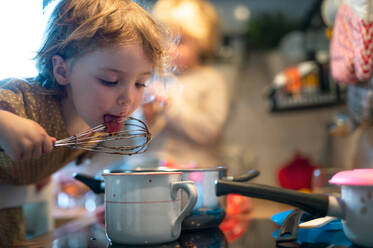 Glücklicher kleiner Junge und Mädchen drinnen in der Küche zu Hause, die beim Kochen helfen. - HPIF13482