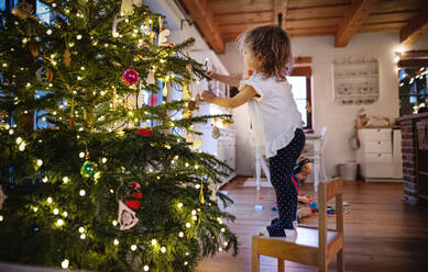 Seitenansicht Porträt des kleinen Mädchens drinnen zu Hause zu Weihnachten, Dekoration Baum. - HPIF13553