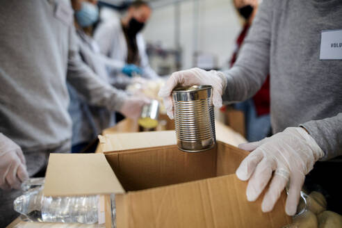 Ein Mittelteil einer Gruppe von Freiwilligen in einem kommunalen Spendenzentrum, einer Lebensmittelbank und einem Coronavirus-Konzept. - HPIF13624
