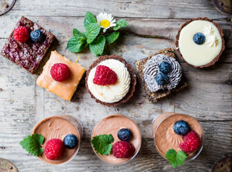 Eine Auswahl an farbenfrohen und köstlichen Kuchendesserts auf einem Holztisch. - HPIF13662