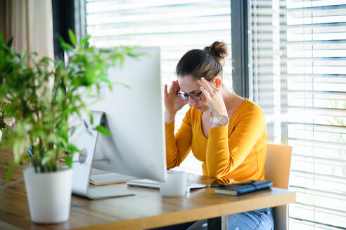 Besorgte Frau bei der Arbeit im Büro zu Hause, Corona-Virus und Quarantänekonzept. - HPIF13715