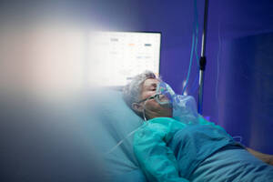 An infected patient in quarantine lying in bed in hospital, coronavirus concept. - HPIF13746