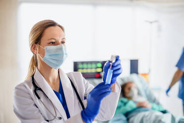 Portrait of doctor with syringe in quarantine in hospital, coronavirus concept. - HPIF13765