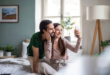 Ein glückliches, verliebtes Paar hält einen Moment der Intimität und des Glücks fest, indem es ein Selfie in seinem gemütlichen Zuhause macht - HPIF13772