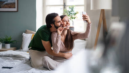 Ein glückliches Paar fängt einen Moment der Intimität und des Glücks ein, indem es ein Selfie in seinem eigenen Zuhause macht - HPIF13773