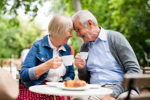 Porträt eines glücklichen, verliebten älteren Paares, das im Freien in einem Café sitzt und Spaß hat. - HPIF13864