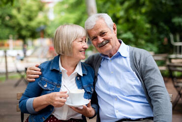 Porträt eines glücklichen, verliebten älteren Paares, das im Freien in einem Café sitzt und Spaß hat. - HPIF13897
