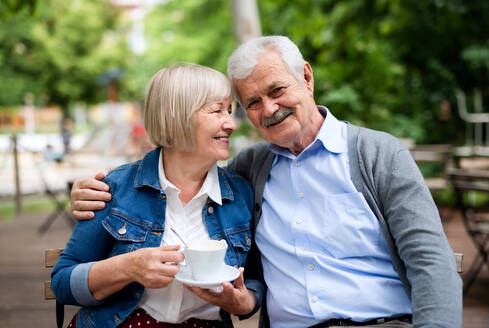 Porträt eines glücklichen, verliebten älteren Paares, das im Freien in einem Café sitzt und Spaß hat. - HPIF13897